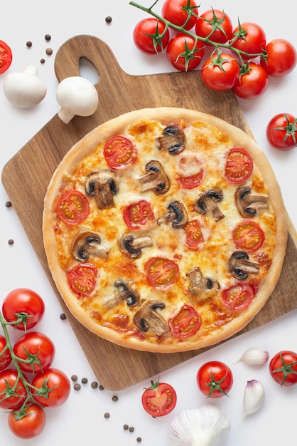 Pizza margherita z pieczarkami i bazylią na drewnianej desce i białym tleKulinarne tło