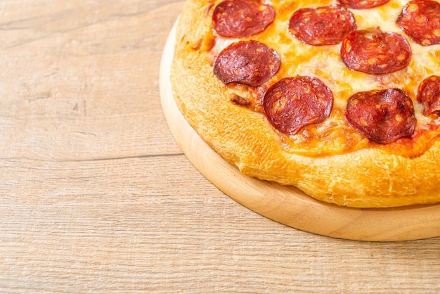 Pizza pepperoni na drewnianej tacy - włoskie jedzenie