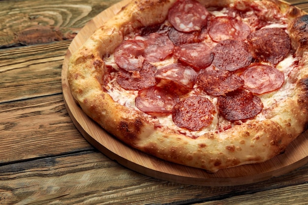 Pizza Pepperoni na tle drewna w stylu rustykalnym, vintage. Widok z góry