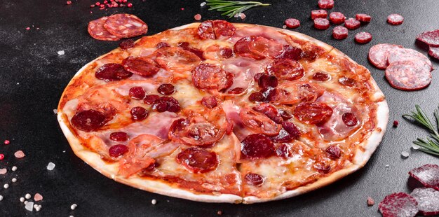 Pizza Pepperoni z mozzarellą, salami, pomidorami, pieprzem i przyprawami. Kuchnia włoska