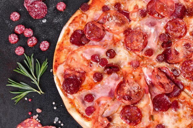 Pizza Pepperoni z mozzarellą, salami, pomidorami, pieprzem i przyprawami. Kuchnia włoska