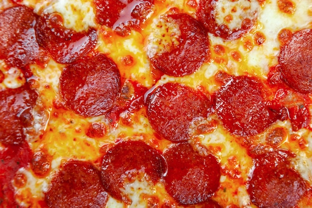 Pizza Pepperoni z pomidorami koktajlowymi, ser na czarnym tle