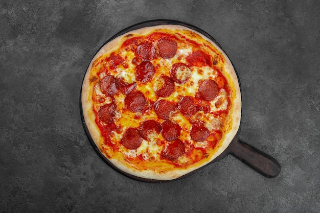 Pizza Pepperoni z pomidorami koktajlowymi, ser na czarnym tle