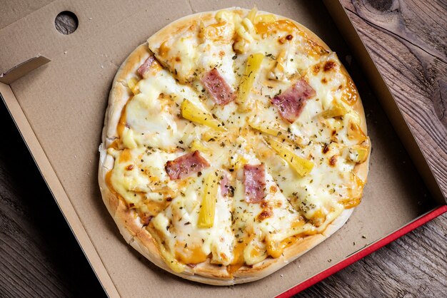 Zdjęcie pizza w pudełku, pizza domowe włoskie jedzenie smaczna pizza serowa szynka i owoce ananasa