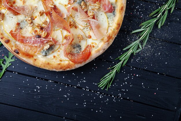 Pizza Z Jamon, Gorgonzola I Parmezanem, Orzechami I Gruszką. Widok Z Góry. świeża Domowa Włoska Pizza. Tło żywności Pizza Z Mięsem I Serem Na Ciemnym Drewnianym Tle