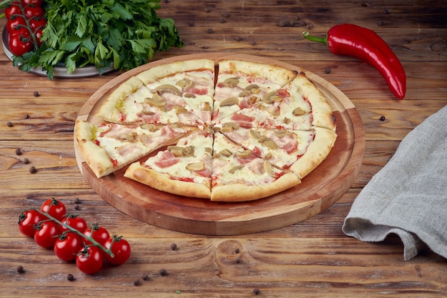 Pizza z mięsem, warzywami i grzybami, drewniane tła