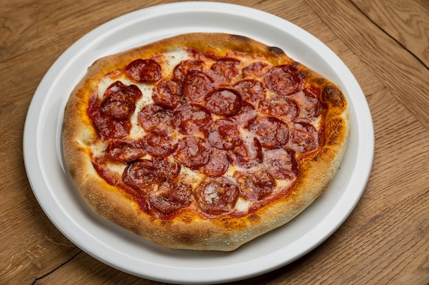 Pizza z pepperoni na nim na talerzu