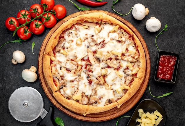 pizza z pieczarkami z kurczaka i ananasem na kamiennym tle