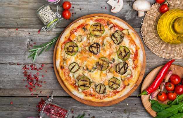 Pizza Z Pomidorami, Mozzarellą, Czarnymi Oliwkami I Bazylią. Wyśmienicie Włoska Pizza Na Drewnianej Pizzy Desce. Widok Z Góry Stołu