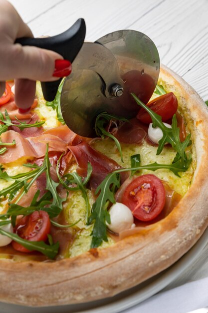 Pizza z prosciutto, mozzarellą i mozzarellą na wierzchu