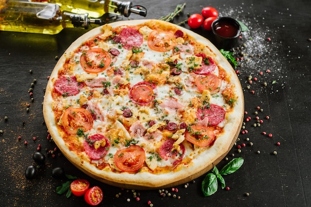 Pizza z salami i szynką na czarnym tle