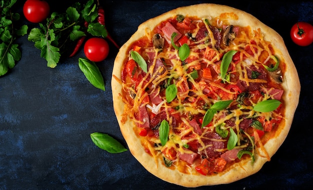 Pizza z salami, szynką, pomidorem, serem i grzybami