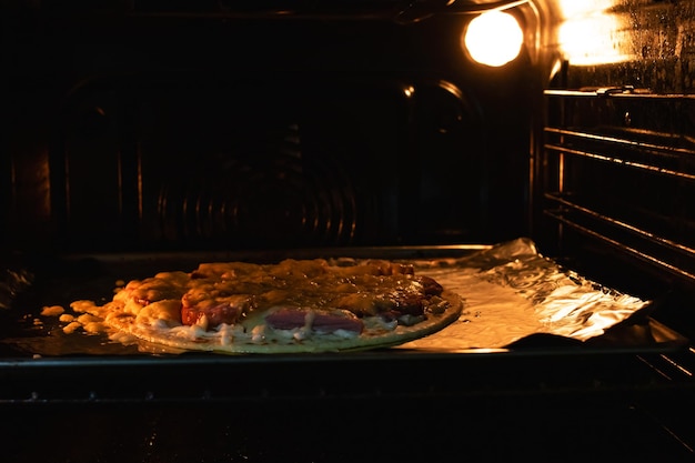 Pizza z serem w piekarniku zbliżenie