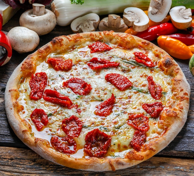 Pizza z suszonymi pomidorami, rukolą i mozzarellą w pizzerii