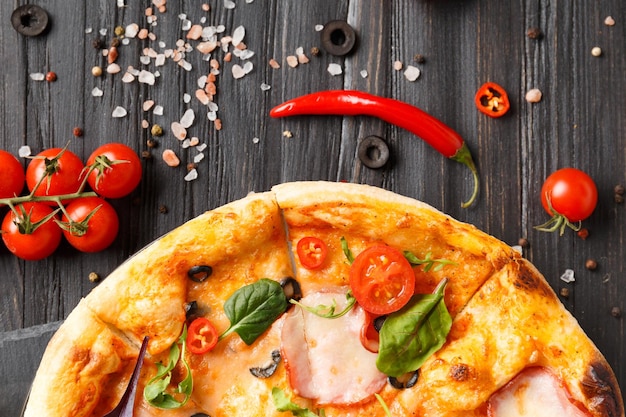 Pizza z szarpanym na czarnym kamiennym talerzu na ciemnym drewnianym tle Selekcyjna ostrość