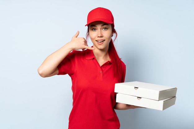 Pizzy doręczeniowa kobieta trzyma pizzę nad odosobnioną ścianą robi telefonu gestowi. Zadzwoń do mnie znak