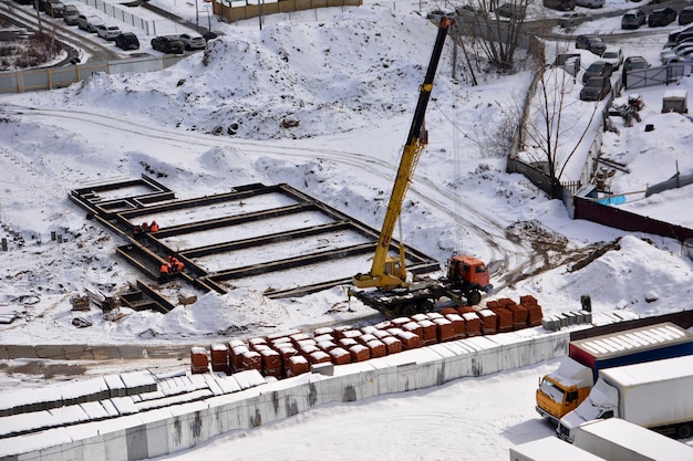 plac budowy z dźwigiem budowlanym na wiosnę, widok z góry