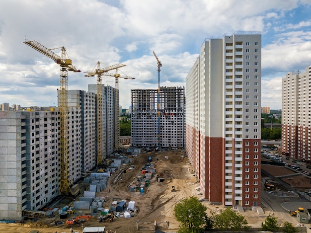 Plac budowy z wielopiętrowymi budynkami, żurawiami wieżowymi i sprzętem budowlanym