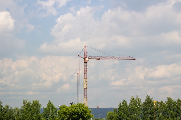 Plac budowy z wieżowcem w budowie w środowisku miejskim zdominowanym przez duży dźwig przemysłowy, na tle pięknego pochmurnego zachodu słońca. krajobraz budowlany