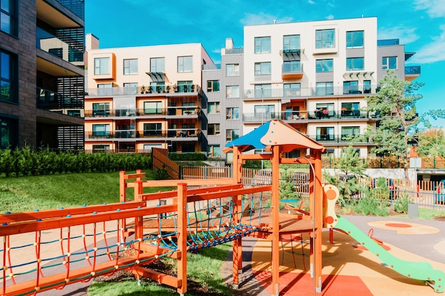 Plac zabaw dla dzieci i europejski nowoczesny zespół osiedla budynków mieszkalnych. Z wyposażeniem zewnętrznym.