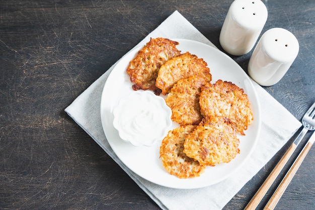 Zdjęcie placki ziemniaczane lub latkes lub draniki z kwaśną śmietaną jedzenie ukraińskie danie z tartych ziemniaków deruny lub draniki