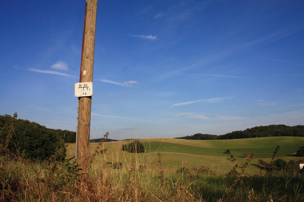 Zdjęcie plakat na drewnianym słupie na polu na tle nieba