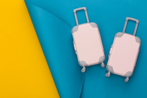 Planowanie podróży. Dwa bagaże podróżne Toy na niebiesko-żółtym kolorze. Leżał płasko. Skopiuj miejsce