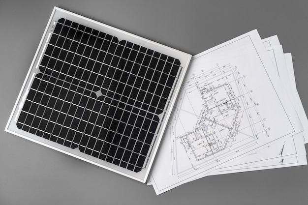 Zdjęcie plany architektoniczne i panel słoneczny na stole