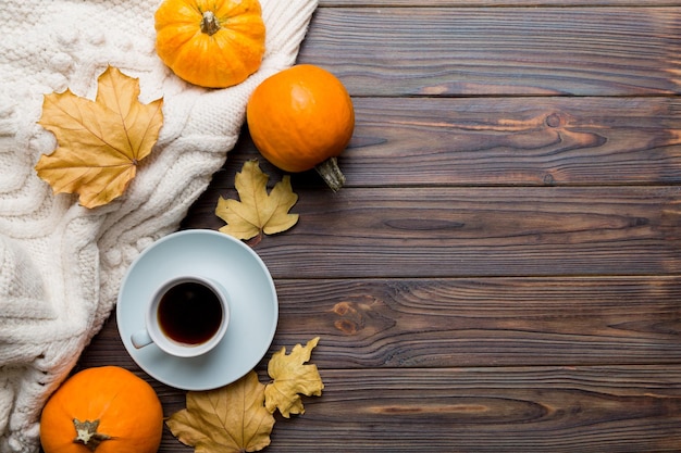 Płaska kompozycja świecka z kolorową jesienną filiżanką kawy i liśćmi na kolorowym tle widok z góry
