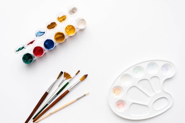 Zdjęcie płaska kompozycja zestaw narzędzi artystycznych pędzle farby ołówki pastele do rysowania miejsce na tekst