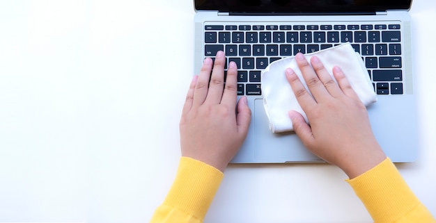 Płaska świecka dama ręka używa ściereczki do czyszczenia laptopa na białym tle