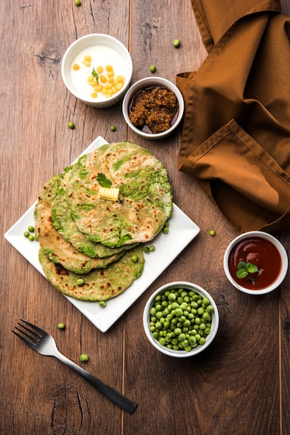 Płaski chleb nadziewany zielonym groszkiem lub Matar ka Paratha to tradycyjna potrawa z północnych Indii. podawane z marynatą z mango, na nastrojowym tle, selektywne skupienie