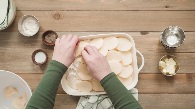 Płaski Układanie. Przygotowanie Zapiekanych Ziemniaków W Białej Ceramicznej Naczyniu Do Pieczenia.