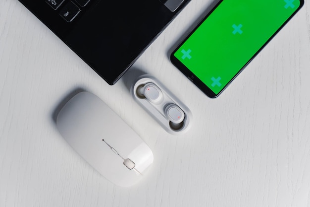Płaskie ujęcie gadżetów i urządzeń mobilnych na białym tle Makieta zielonego ekranu smartfona