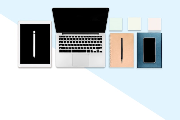 Płaskie zdjęcie świeckich stół biurowy z laptopem, tabletem cyfrowym, telefonem komórkowym i akcesoriami.