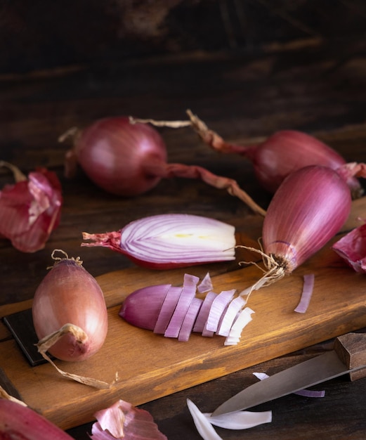 Plasterki czerwonej cebuli tropea z nożem na drewnianej desce z bliska Tradycyjne lokalne warzywa z południowych Włoch Proces gotowania w domowej kuchni
