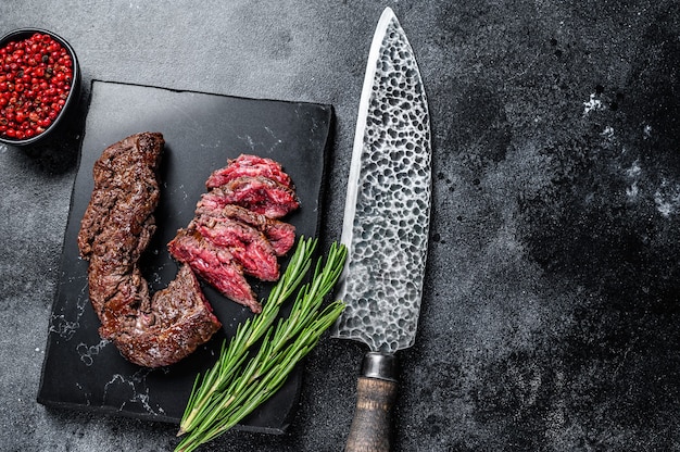 Plasterki Grillowany Stek Onglet Wiszący Tender Na Marmurowej Desce. Czarne Tło. Widok Z Góry. Skopiuj Miejsce.