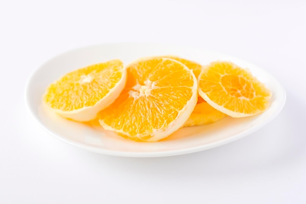 Plasterki pomarańczy na białym talerzu