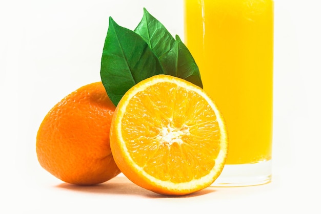 Plasterki pomarańczy ze szklanką soku pomarańczowego na białym tle