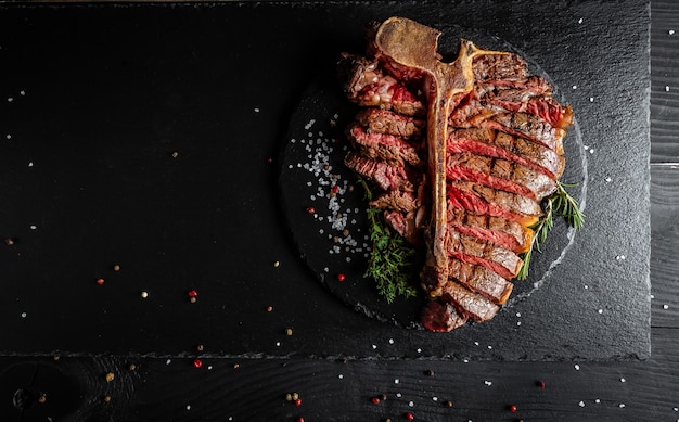 Plasterowany Stek T-bone lub stek wołowy z grilla wagyu porterhouse Średnio wysmażony na kamiennym stole