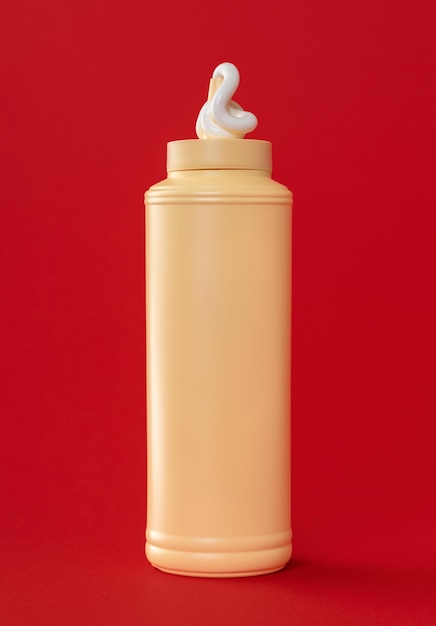 Zdjęcie plastikowa butelka z majonezem na czerwonym tle