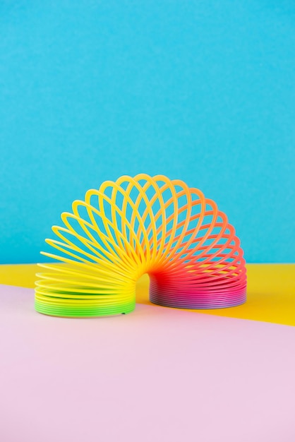 Plastikowa tęcza z lat dziewięćdziesiątych zabawka na kolorowym tle orientacja pionowa