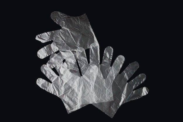 Plastikowa torba z uchwytami rękawiczki na czarnym tle Zużyta plastikowa torba do recyklingu Koncepcja ekologia zanieczyszczenie planety plastikowym celofanowym polietylenem