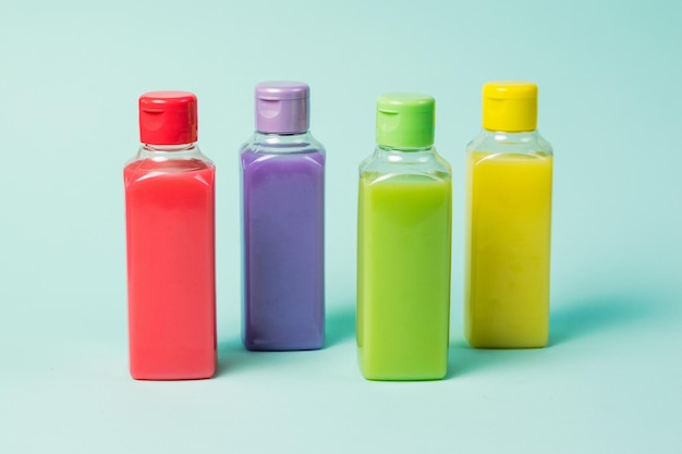 Plastikowe butelki w czterech kolorach na niebieskim tle