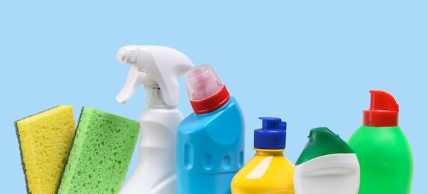 Plastikowe butelki z domowym środkiem czyszczącym na niebieskim tle