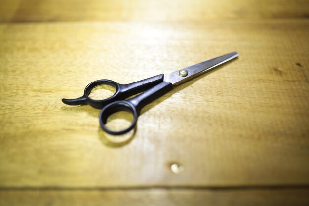 Zdjęcie plastikowe nożyczki fryzjerskie izolowane na drewnianym tle