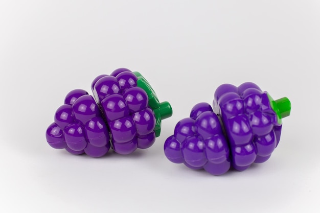 Plastikowe zabawkowe winogrona na białym tle