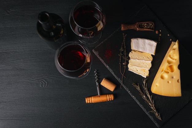 Plastry sera i kieliszek wina na stole