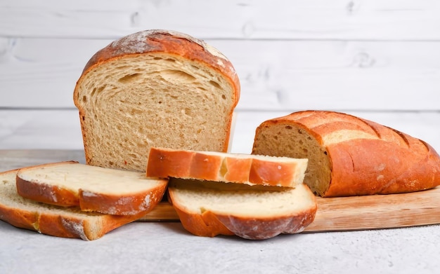 Płaszcze chleba i pyszny kawałek chleba z zakwasem na odizolowanym białym tle