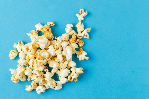 Płatki popcornu na niebieskim tle zbliżenie poziomo